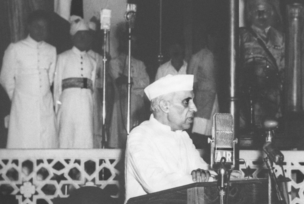 Jawaharlal Nehru delivering his famous “Tryst with Destiny” speech on the eve of India’s independence, August 15, 1947. Nehru stands behind a microphone addressing the nation, symbolizing the dawn of a free India.