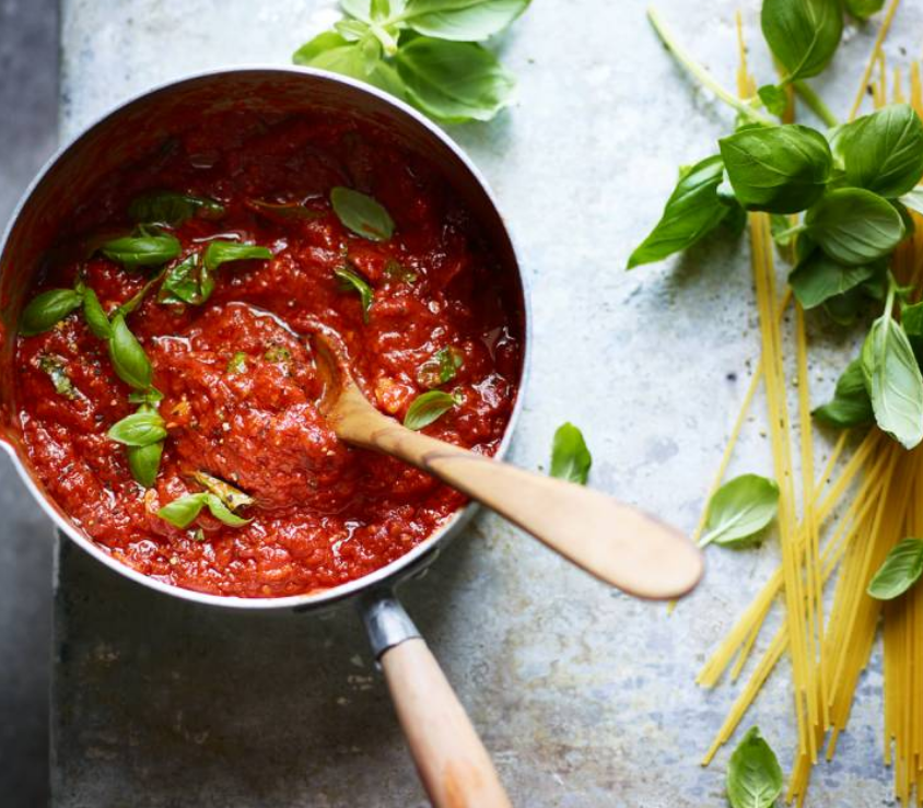 Rich tomato sauce with fresh basil in a saucepan, ready to be used in pasta dishes.
