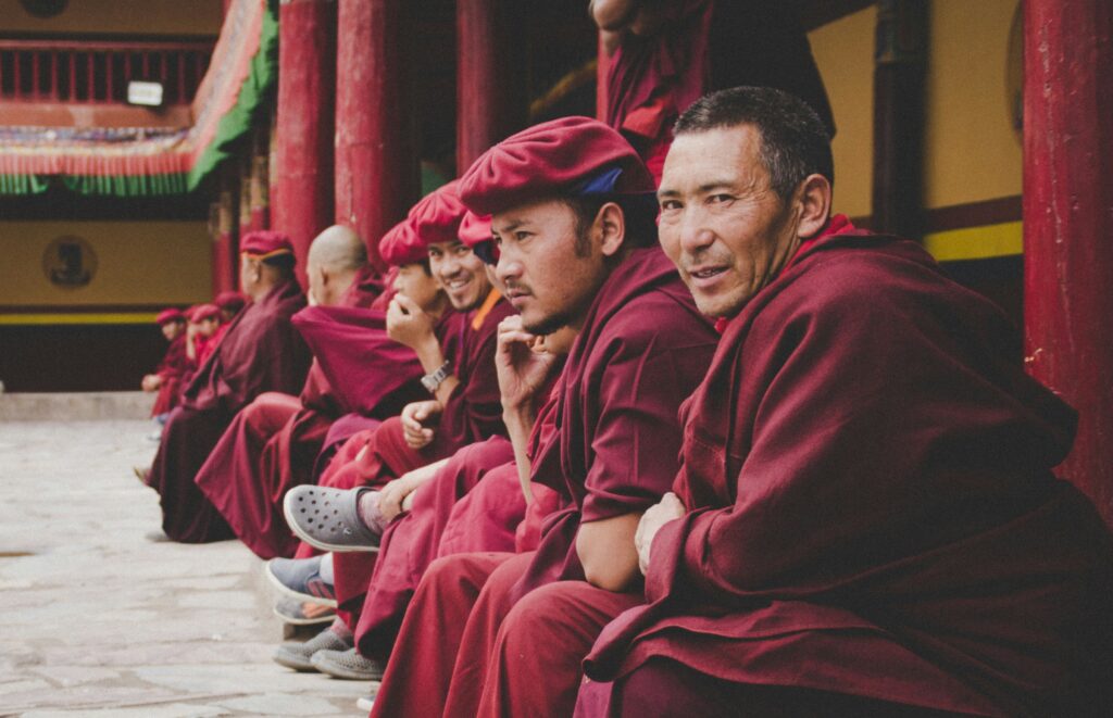 A group of Ladakhi Buddhist monks sitting together at a monastery