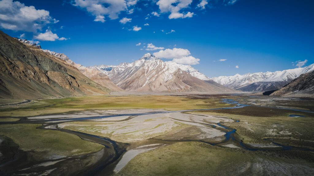 A vibrant valley surrounded by snow-capped mountains in Ladakh