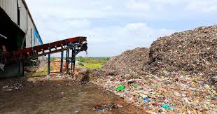 A large pile of waste next to a conveyor system at a waste processing facility in Bengaluru, underscoring the massive amounts of garbage the city generates daily. Doddaballapura taluk